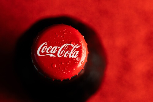 logo della coca-cola sul tappo di una bottiglia di vetro